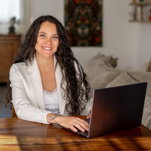 Femme Sexologue et thérapeute de couple, derrière son bureau face à son ordinateur